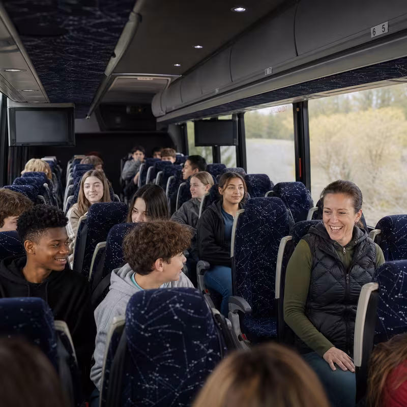 Group boarding a white charter bus for School Transportation transportation in Grand Prairie